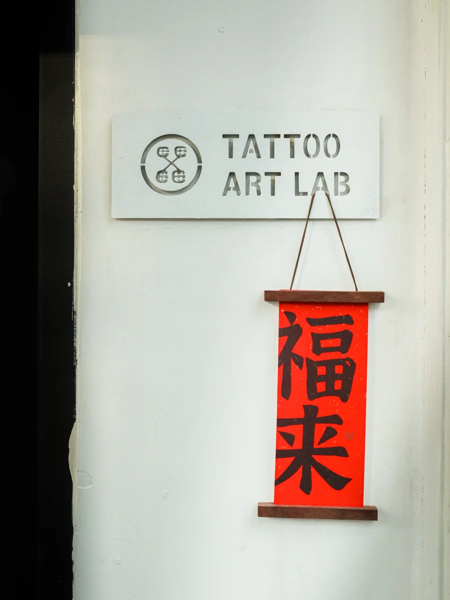 Tattoo Art Lab entrance sign at Lei Shi Tattoo Beijing with traditional Chinese 福来 blessing banner
